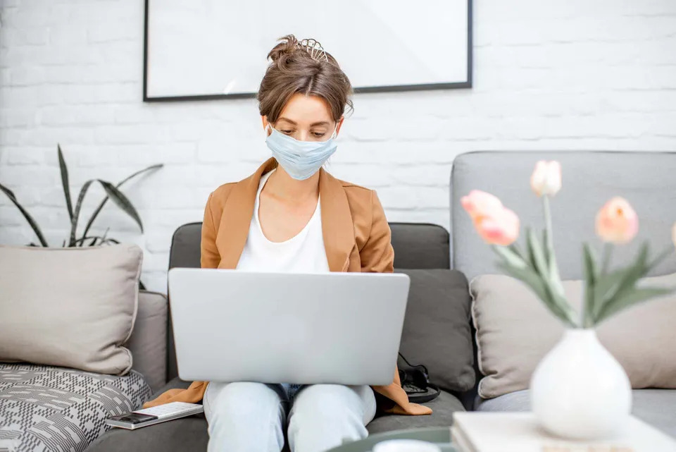 woman-in-medical-mask-working-from-home-B49RM8X-min-960w